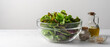 © Anna Puzatykh - Mix of green salad in glass bowl on the table. Simple food for diet or healthy eating. Side view, light white background