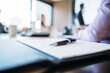 © Cavan Images - Close-up of pen and document on table with business people in background