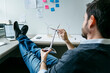 © Cavan Images - Businessman spinning windmill model while sitting in office