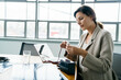 © Cavan Images - Businesswoman fixing battery while working on solar panel in office