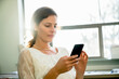 © Cavan Images - Businesswoman using smart phone while sitting in office