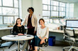 © Cavan Images - Portrait of businesswomen at desk in office
