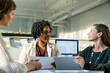© Cavan Images - Businesswomen discussing over tablet computer while sitting in office