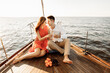 © Александр Шуневич - Lovely couple in love on a yacht drinking champagne, luxury rest on the ship.