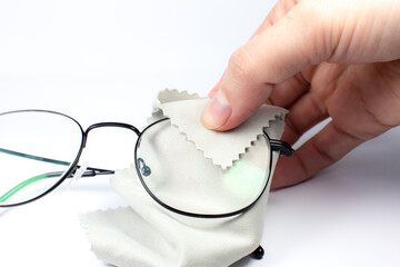 Wall Mural - Woman cleaning reading glasses with cloth. Close up photo.