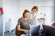 © Cavan Images - Businesswomen working on laptop in creative office