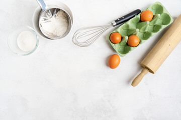 Kitchen background for mockup with eggs, rolling pin, bowls for cooking and baking utensils on the table on white background. Blank space for a text, home kitchen decor concept. Wide banner.