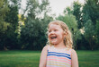© Cavan Images - Cheerful girl looking away while standing at park