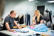 © Cavan Images - Fashion designers working on fabric swatches at table in design studio