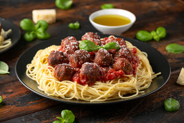 Vegetarian spaghetti with meat free, vegan meatballs in rich tomato sauce, grated cheese and basil leaves