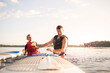 © Cavan Images - Father and son enjoying at lake against sky on sunny day