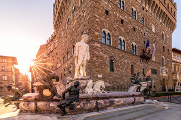 Wall Mural - Fountain of Neptune on empty Piazza della Signoria in the rays of the rising sun. Florence, Italy