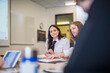 © Cavan Images - Pilot trainees studying while sitting at desk in classroom