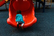 © Cavan Images - Little girl climbing slide at playground