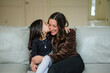 © Cavan Images - loving mother and daughter hugging on couch at home