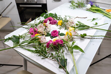 Backstage Of The Subject Shooting With Flowers. A Composition For Photographing Flowers Is Spread Out On The Kitchen Table