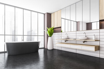 White and black bathroom with two sinks and bathtub near window