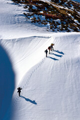 Wall Mural - Des hommes marchent sur la neige en montagne, randonnée sur neige