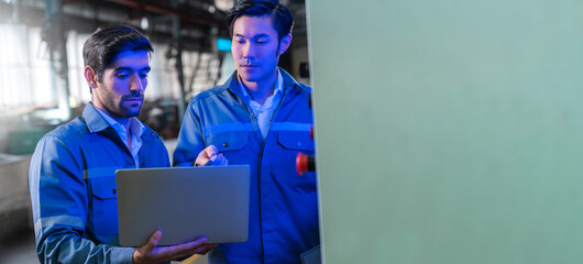 Male Asian caucasian engineer professional having a discussion standing consult at machine in the factory ,two expert coworker brainstorm explaining and solves the process of the cnc operate machine