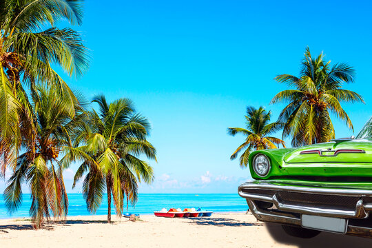 Wall Mural -  - The tropical beach of Varadero in Cuba with green american classic car, sailboats and palm trees on a summer day with turquoise water. Vacation background.