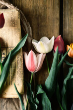 A Bouquet Of  Tulips With Green Leaves  On A Wooden Table