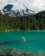 © Cavan Images - A girl does a belly flop into the vibrant blue Joffre Lakes.