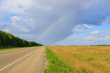 Fototapeta Tęcza - view from the side of the road and the rainbow above it