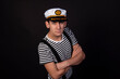 © Denis - Handsome guy on a black background. Captain of a sea vessel. Positive and negative emotions.