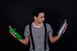 © Denis - Funny young guy and cleaning supplies. Detergents and mop. Black background.