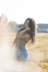 Sticker - Beautiful Asian girl wearing a crop top and a jean skirt posing for the camera in the flower field