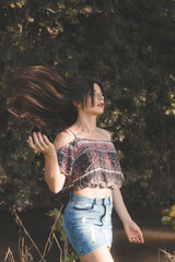 Poster - Beautiful Asian girl wearing a crop top and a jean skirt posing for the camera at the park