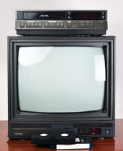 Old TV With VCR On The Background Of Wallpaper.