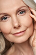 © insta_photos - Happy attractive 50 years old middle aged mature woman touching healthy soft face skin looking at camera. Anti age dry skin care tightening treatment ads. Face close up view crop detail portrait