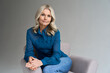 © insta_photos - Middle aged female psychotherapist, counselor sitting in chair alone in office looking at camera. Sophisticated elegant mature 50s woman of mid age with blond hair posing indoors, portrait.