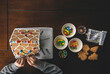 © Cavan Images - Cropped hands of boy making gingerbread house on wooden table during Christmas at home