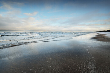 Wall Mural - Frozen Baltic sea shore at sunset, snow texture close-up. Dramatic sky. Picturesque winter scenery. Seasons, nature, ecology, environment, climate change, global warming. Panorama, copy space