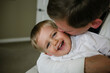 © Cavan Images - Happy father kissing son while sitting at home