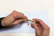 © Cavan Images - Cropped hands of engineer sharpening pencil at desk in office