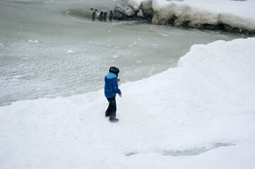 person walking on snow, Winter landscape , Baltic Sea, snowy beach, ice breakwaters, cold water