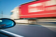 © Cavan Images - Blurred motion of truck moving on road seen through car window