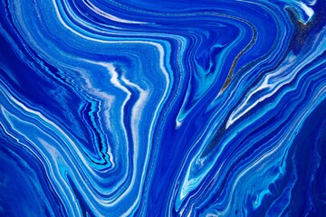Wall Mural - Fluid art texture. Abstract backdrop with mixing paint effect. Liquid acrylic artwork with artistic mixed paints. Classic blue color of the year 2020. Blue, golden and white overflowing colors