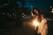 Young woman with torchlight on the beach at night