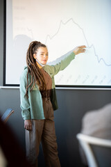 Wall Mural - Young confident female coach in casualwear explaining graph on whiteboard