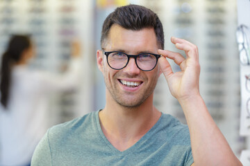 Wall Mural - man trying on new glasses at opticians