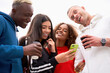 © Andrii - Multi-ethnic group teenage friends looking smartphone screen. African-american asian caucasian student spending time together Multiracial friendship Smiling People colorful sportswear drink coffee