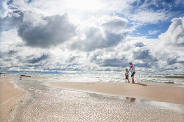 Brothers walking on the beach on a cloudy windy day