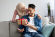 © Prostock-studio - Happy muslim lady with present hugging her surprised lover