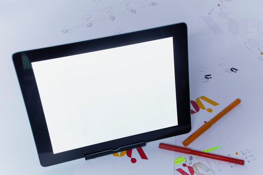 Creative workplace of a Graphic Designer with Tablet. Development of a logo for the company. Drawings and sketches on paper in a art studio office.