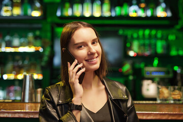 Sticker - Happy young brunette woman in smart casualwear talking on smartphone in bar