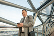 © pressmaster - Mature delegate or businessman in formalwear using smartphone in front of camera